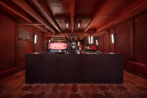 Industrial kitchen with two ovens, three sinks, and a red brick wall, creating a functional and practical atmosphere