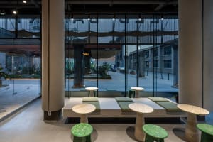 A warm and inviting indoor seating area with multiple wooden tables and chairs, perfect for social gatherings or relaxation