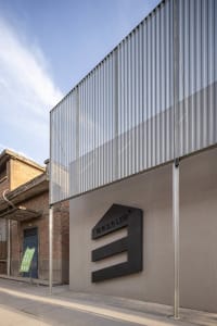 Modern building with a large metal wall and a black sign reading LEB, set against a concrete exterior with a sturdy and durable appearance