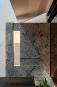 Bathroom with a marble wall and countertop, featuring a sink and mirror in a luxurious and elegant space