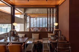 A modern restaurant with multiple tables and chairs, set up for customers, in a comfortable and inviting atmosphere