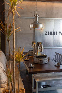Inviting dining area with a wooden table, chairs, and potted plants, creating a warm and welcoming atmosphere