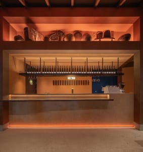 A well-stocked bar area with a countertop featuring a large number of wine bottles displayed in various positions