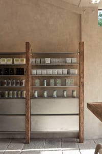 A store display filled with candles, jars, boxes, and bottles, with cups scattered around, creating a visually appealing retail environment