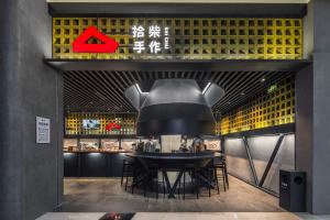 Modern Asian restaurant with black and yellow tones, comfortable seating, and a unique triangle decorative element
