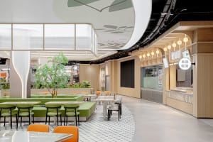 Open restaurant interior with modern design, multiple seating options, potted plants, and inviting atmosphere