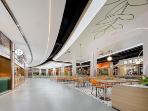 A casual dining area in a shopping mall with multiple tables and chairs, creating a welcoming space for people to eat and socialize
