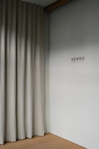A white room with a linen curtain hanging on a wall, with no other objects or details visible