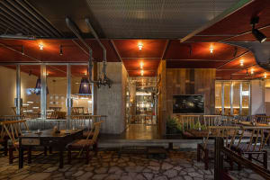 A restaurant with various seating options, potted plants, and a mix of modern and traditional elements