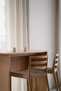 A cozy dining space with a wooden table and two chairs, featuring two cups and a warm atmosphere