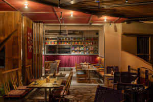 A restaurant dining area with wooden tables and chairs, set with cups, creating an inviting atmosphere for customers