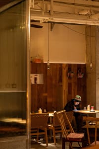 A casual restaurant with wooden furniture, tables, chairs, and various decorative items, creating a welcoming atmosphere