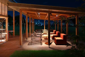 A well-lit outdoor patio with multiple chairs and couches arranged for comfortable seating, perfect for socializing or relaxation