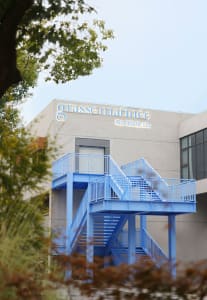 A modern office building with a concrete exterior and a metal staircase leading to a second floor