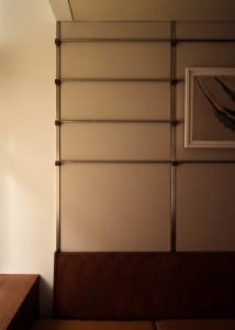 A wooden wall with a metal frame and two pictures, in a cozy and warm interior space