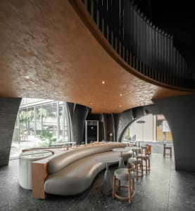 Modern restaurant interior with a bar area, wooden accents, and natural light from windows