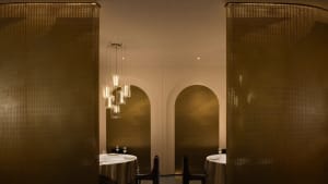 A sophisticated dining area with a large wooden table and chairs, wine glasses, and a warm ambiance