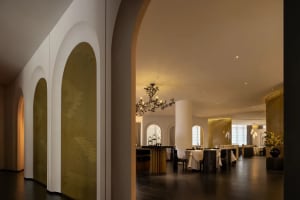 Sophisticated dining area with a large wooden table, multiple chairs, and wine glasses, set in a well-lit space with tasteful decorations