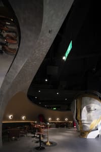 Bright and modern lobby with a sculpture of a face, chairs, and dining tables, well-lit and stylish