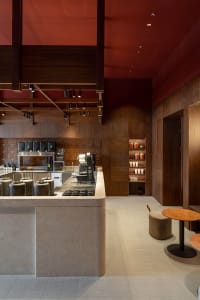 A cozy coffee shop interior with a counter featuring cups, bottles, and bowls, creating an inviting atmosphere for customers
