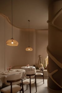 A dining area with a long table and multiple chairs, set with various items, creating an inviting atmosphere for guests