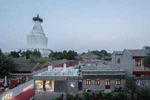 A building with a red roof and white walls, featuring windows on multiple levels, chairs, and a blend of realistic and artistic elements