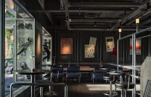 Dimly lit restaurant interior with seating areas, dining tables, and artwork on the walls