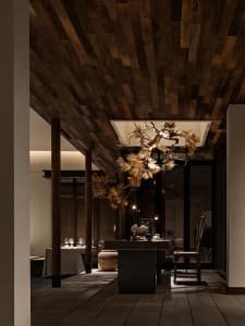 Warm and inviting dining area with a wooden table, chairs, and wine glasses, creating a comfortable environment for social gatherings