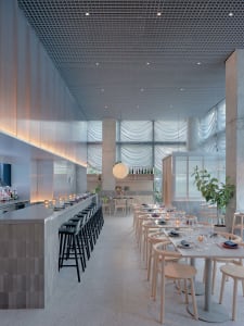 A modern restaurant interior with a large dining area featuring multiple tables and chairs, wine glasses, and a comfortable atmosphere