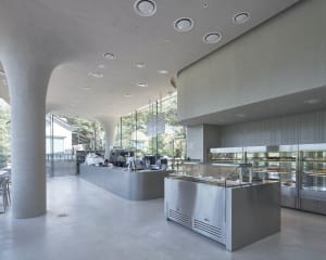 Industrial kitchen with stainless steel appliances, a large refrigerator freezer, and a well-organized countertop with various items