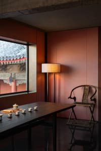 Cozy room with a wooden table, chair, cups, and a bowl, lit by natural light from a window