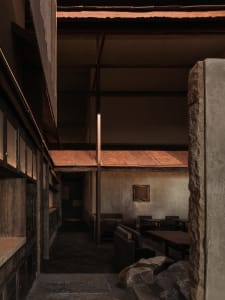 a modern restaurant interior with a dining area, bar, and dim lighting