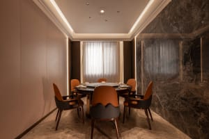 A formal dining area with a round table and four chairs, set for a meal in a calm and inviting environment