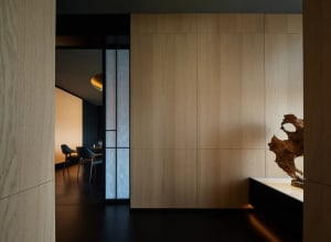 Warm and inviting interior space with wooden walls and floors, featuring a dining table and two chairs