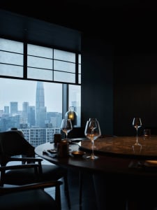 Dining table set with wine glasses, bowls, and cups in a sophisticated restaurant interior