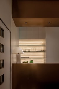 A well-lit kitchen area with a countertop featuring bottles, wine glasses, and cups, creating an inviting atmosphere for socializing or entertaining