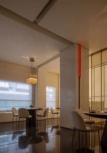 Modern restaurant interior with white walls, dining tables, chairs, and decorative elements