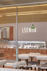 A cozy restaurant dining area with wooden furniture, multiple tables, and chairs, set in a warm and inviting atmosphere