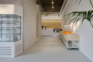 A clean and organized office space with a white floor, a countertop with several oranges, and a neutral atmosphere