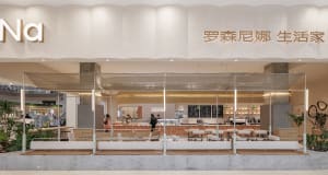 A well-lit restaurant interior with glass walls, wood elements, and dining tables and chairs