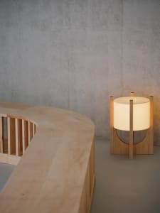 A warm and inviting interior space with a wooden table, two lamps, and a cozy atmosphere