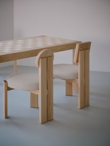 A wooden dining table with two chairs, one on each side, in a cozy and inviting atmosphere