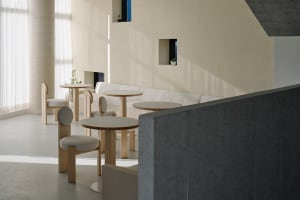 A modern living area with a white couch, multiple chairs, and dining tables, featuring a focus on functionality and comfort