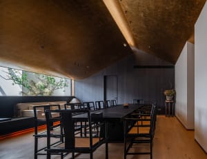A warm and inviting dining area with a large wooden table surrounded by black chairs, perfect for socializing and sharing meals