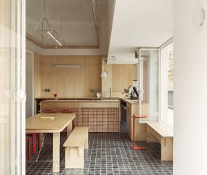 Warm and inviting kitchen with wooden floors and walls, featuring a dining table, kitchen island, and various kitchen items