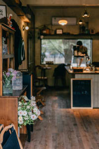 Warm and inviting cafe interior with wooden floor, chairs, tables, and decorative vases