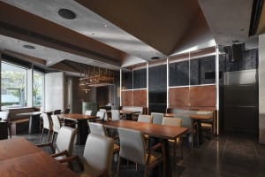 Dimly lit restaurant interior with wooden tables, chairs, and flooring, creating a calm and inviting atmosphere