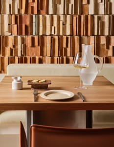 Dining area with a wooden table, chairs, and various tableware, set in a sophisticated and inviting atmosphere