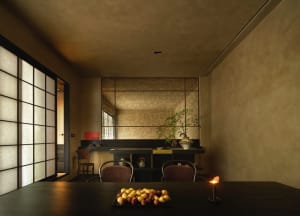 Cozy dining space with a concrete wall, a dining table, chairs, fruit, and cups