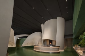 Warm and inviting restaurant interior with a large fireplace, white walls, and two sinks near the fireplace